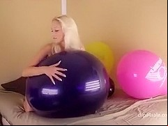 Blond girl bounce some big balloons